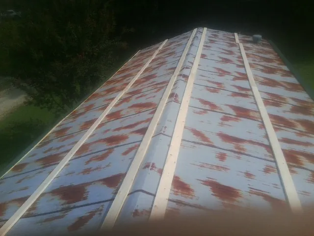 Rusted metal roof panels with new wood purlins before replacement — Storm Damage Roof Repair in Jenkinsville by Roofing Brothers