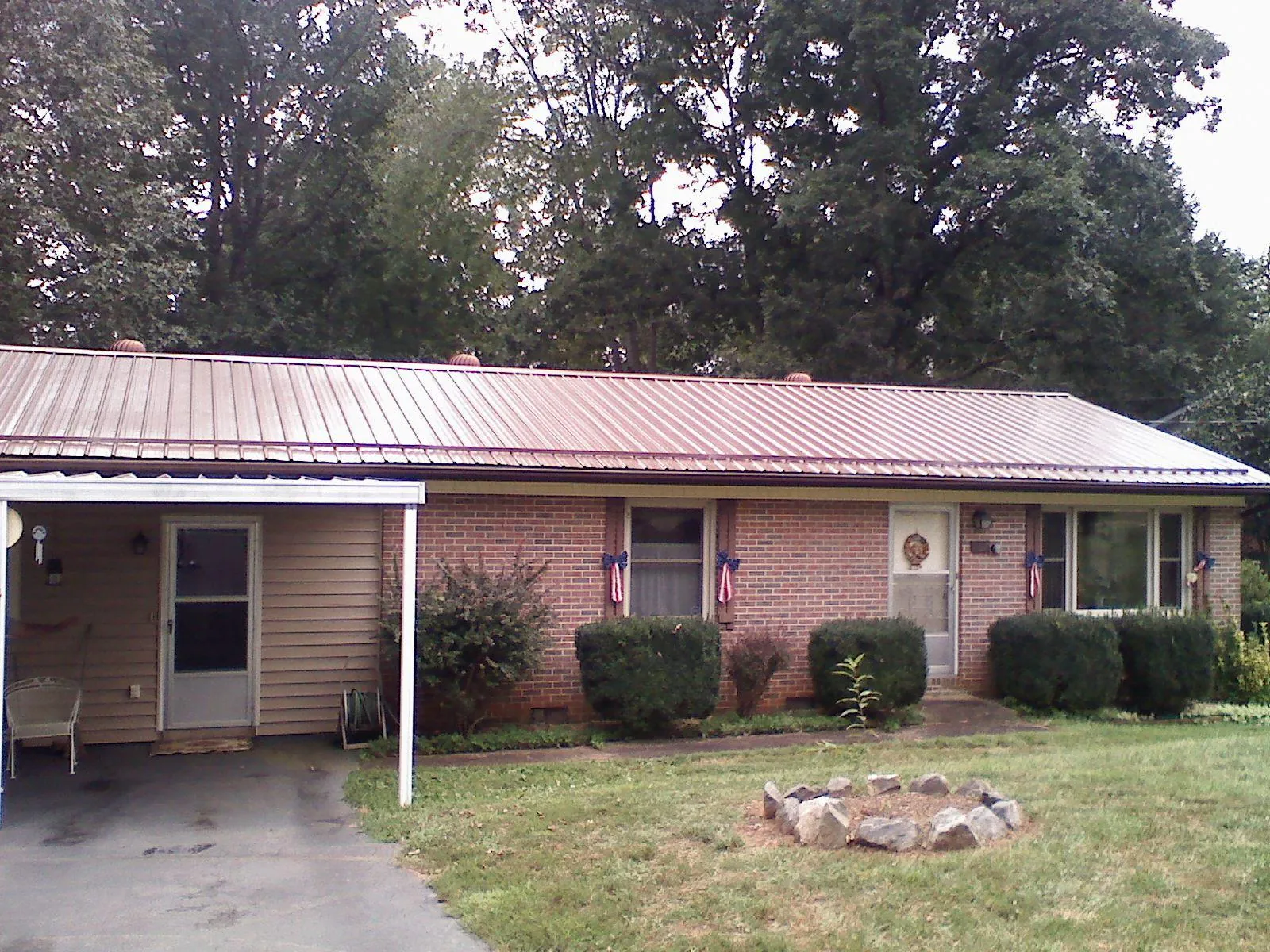 Bronze metal roof and carport on a brick ranch home — Roof Repair work by our crew in Jenkinsville